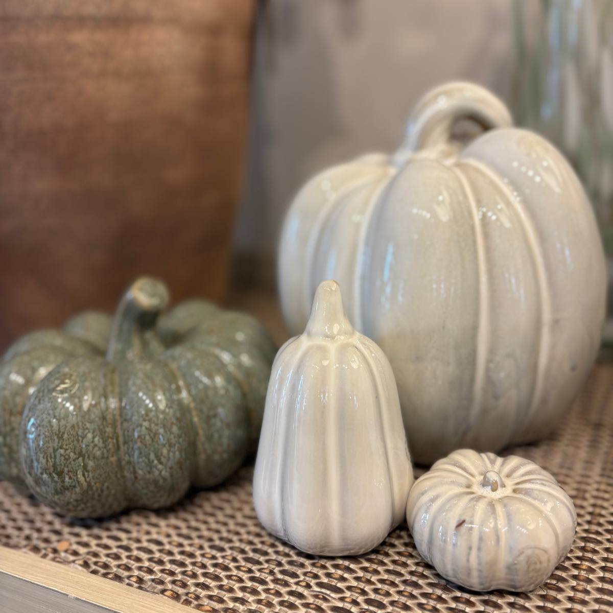 Hallia Small Ceramic Pumpkin in Off White -displayed with decorative ceramic pumpkins in various sizes on a textured surface