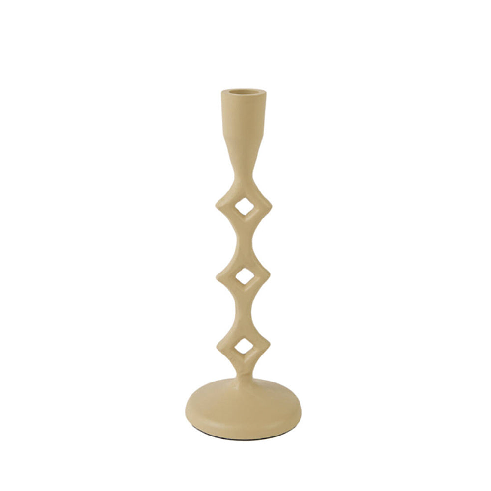 A single sand ceramic candlestick holder with a unique geometric design featuring four stacked diamond-shaped cutouts on a slender stem, set against a plain white background.