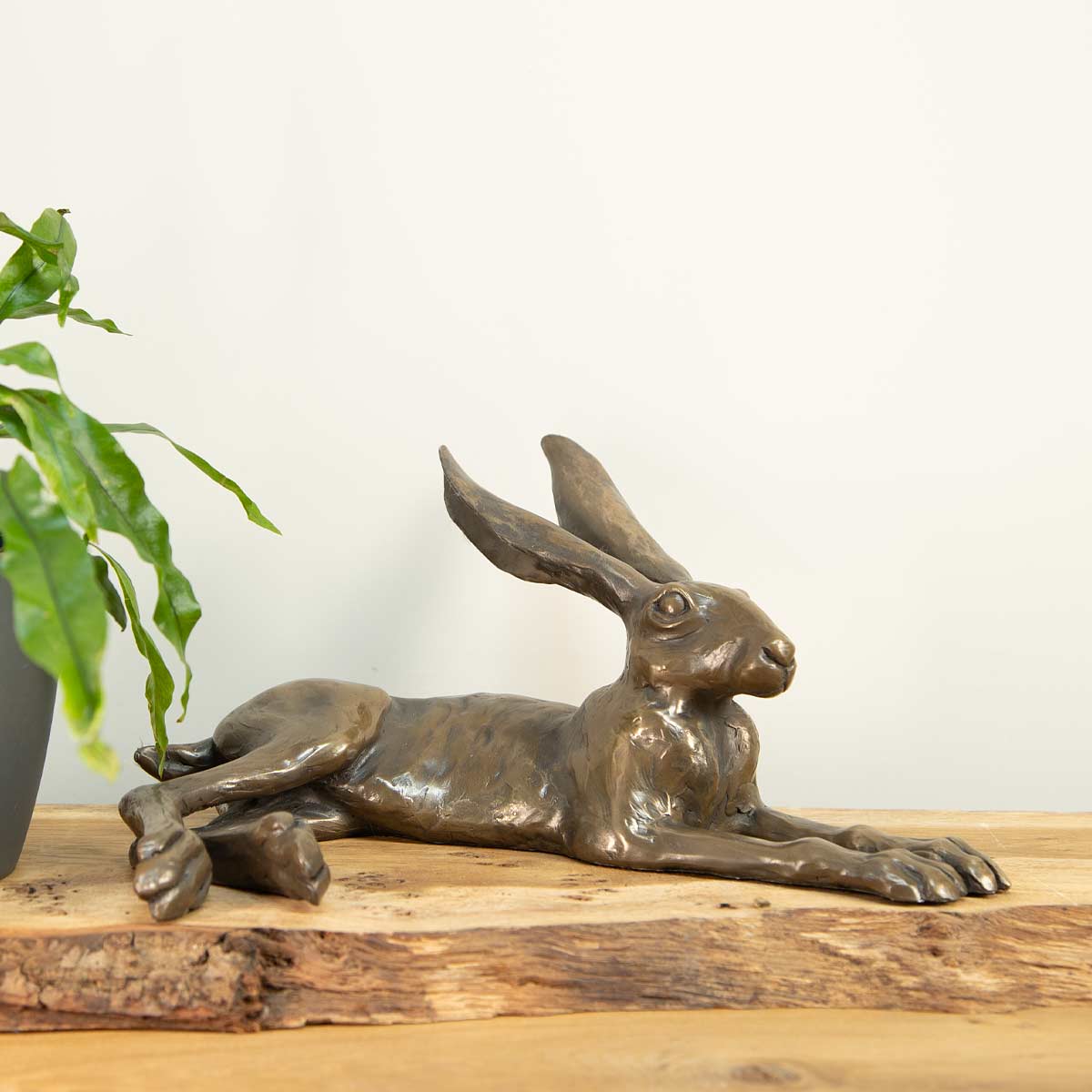Bronze resin hare sculpture handcrafted in the UK – Joanna Martins design. Displayed on rustic shelf.

