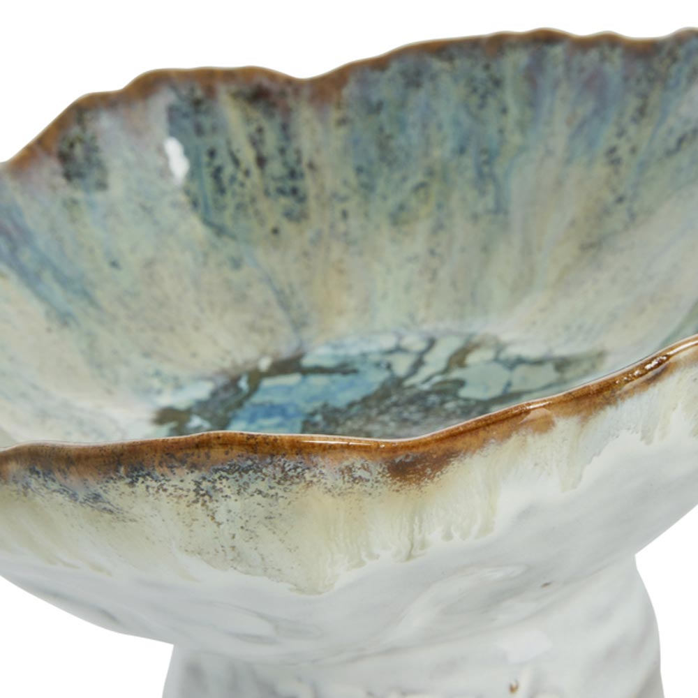 Close-up of Milla Reactive Glaze Bowl on Stand in Green with textured surface and brown rim on a white background