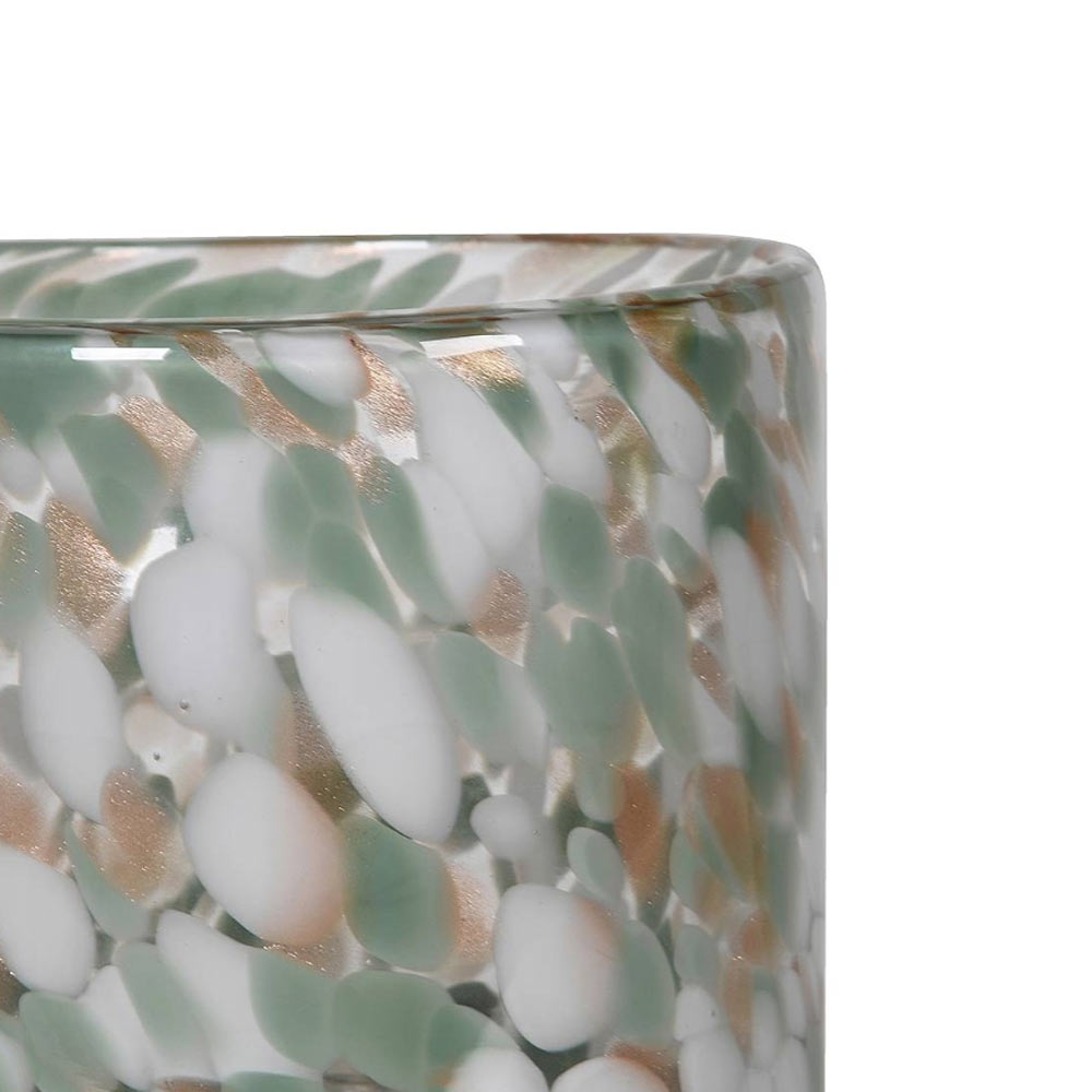 Close up of pistachio Speckled Glass Hurricane with green, white and gold flecks on a white background