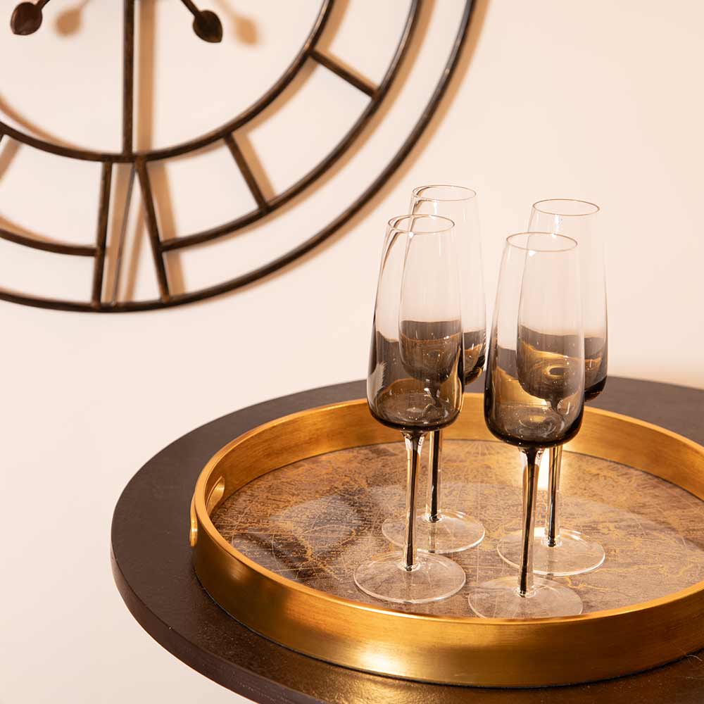 Smoke Champagne glasses on the Round World Map Trayy with a clock in the background