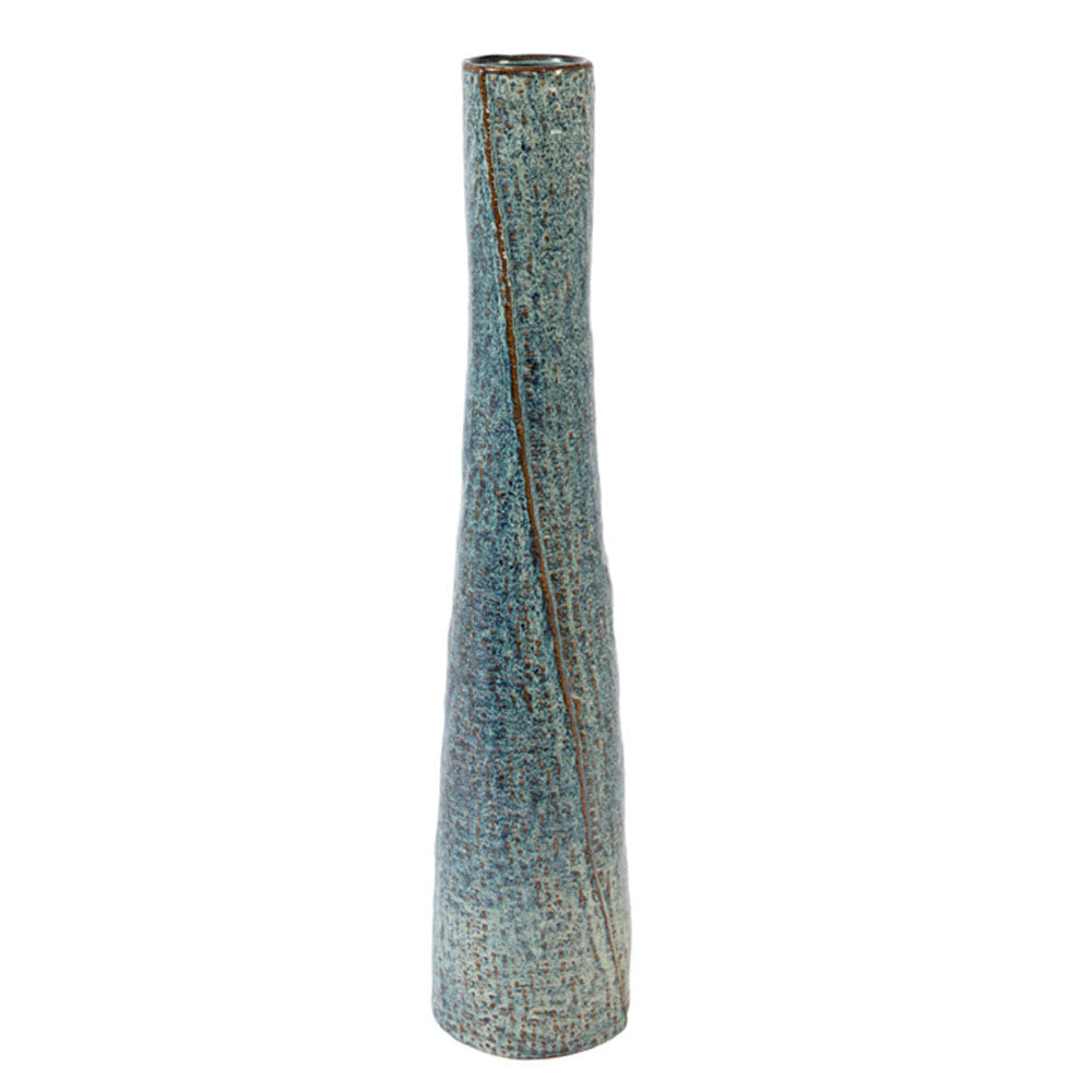 A tall, slender ceramic vase with a textured, speckled blue and brown  glaze and a vertical twisting line running down the central area, shown on a plain white background.