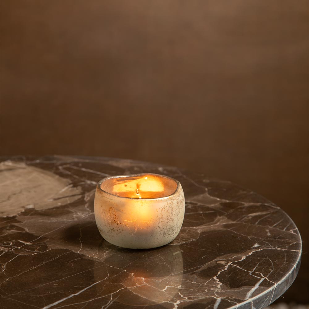 Small Sungai Antique Gold Glass Candle Holder on a marble table against a brown background