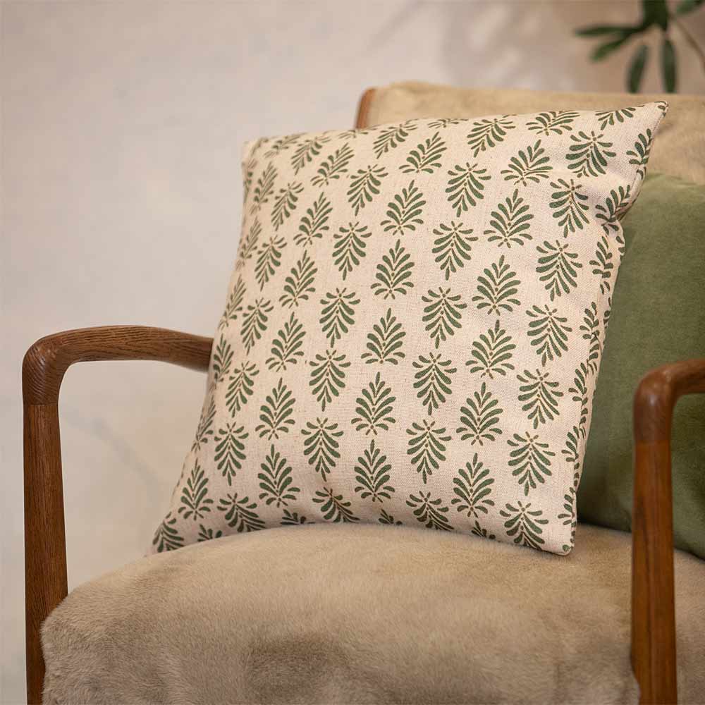 Patterned pillow on a wooden framed chair with a neutral background