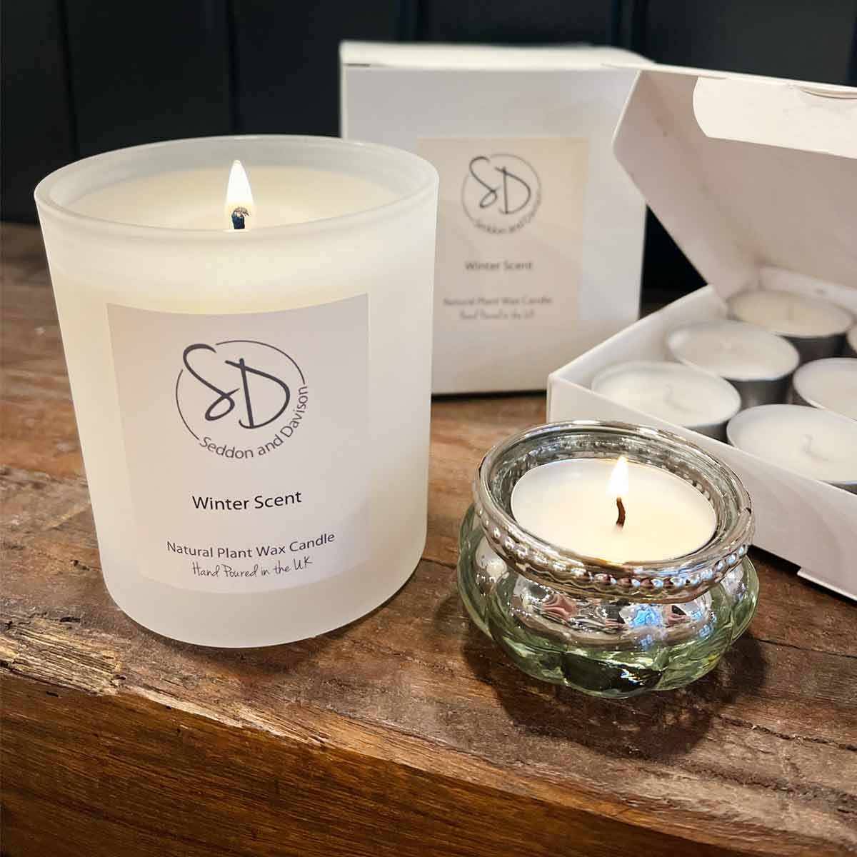 Hand-poured Winter Scent candle by Seddon and Davison, made with natural plant wax and shown with tealights and a glass tealight holder on a wooden surface.